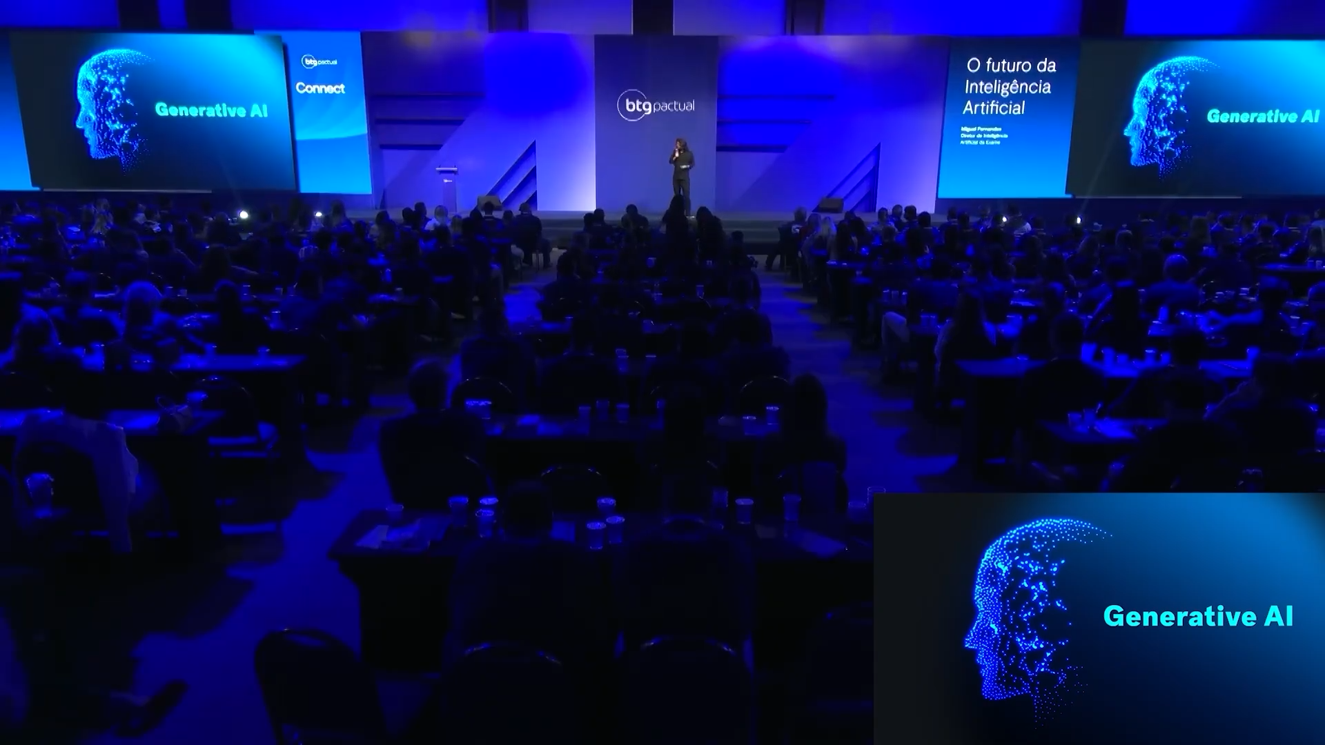 Miguel on stage at BTG Pactual Connect, speaking to a large auditorium.